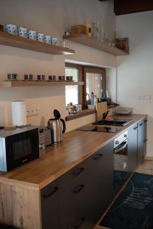 una cucina con piano di lavoro in legno e forno a microonde di Srub v Odeři a Hroznětín