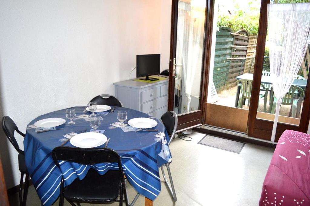 une table avec des chaises et un chiffon de table bleu dans l'établissement Maison Studio cabine mezzanine 4 couchages ARGELES SUR MER AR440-126, à Argelès-sur-Mer