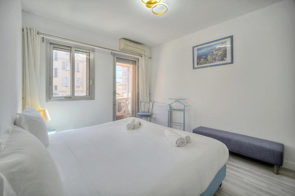 une chambre blanche avec un lit et une fenêtre dans l'établissement Immogroom - large apartment clim/terrace - wifi, à Cannes