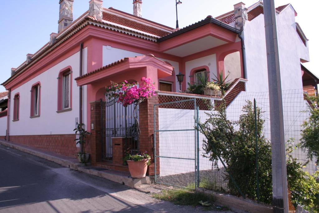 ヴィッラ・サン・ジョヴァンニにあるLa Villettaの花塀付白ピンクの家