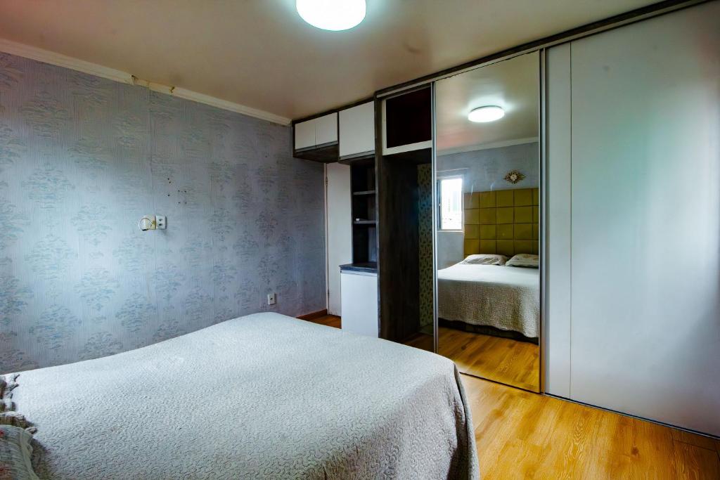 ein Schlafzimmer mit einem Bett und einer Spiegelwand in der Unterkunft Duplex Confort boa viagem perto de tudo in Recife