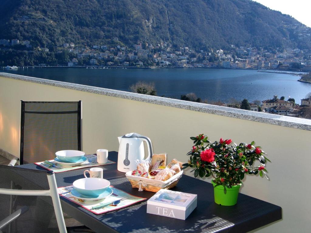 un tavolo con cibo e una vista sul lago di Appartamento Franca a Como