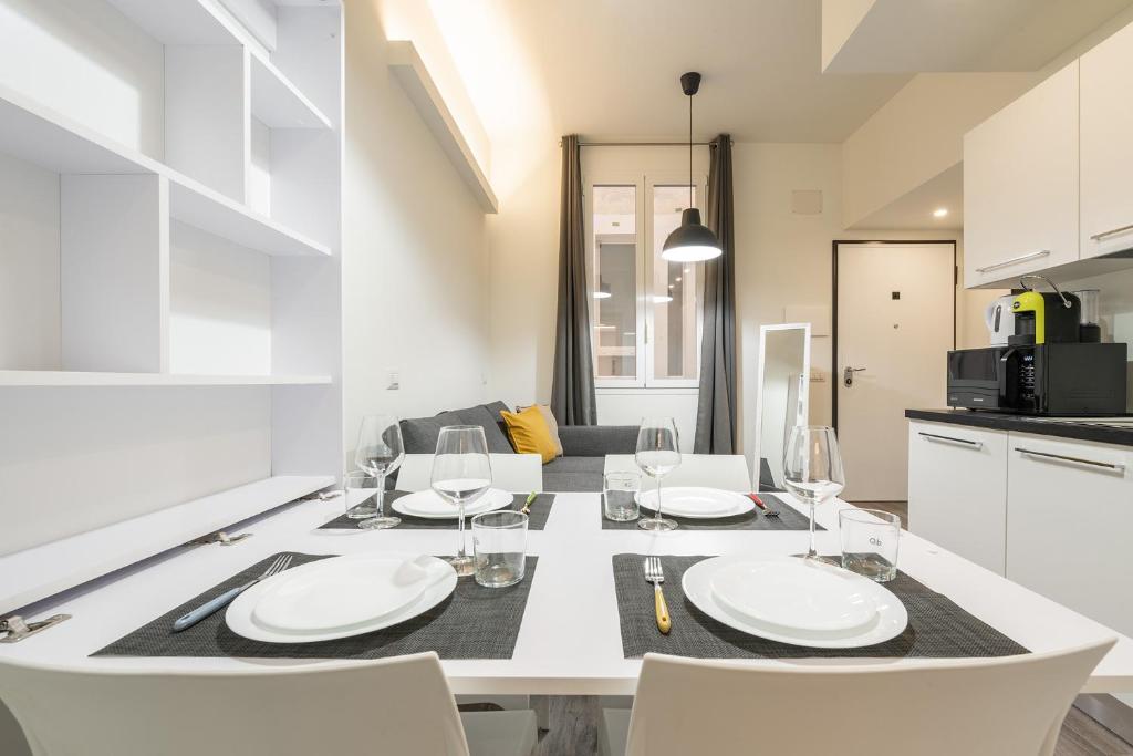 una sala da pranzo con tavolo e sedie bianchi di Lumen - Downtown Vibes a Cagliari