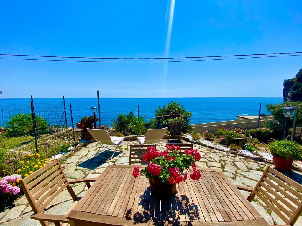 a wooden table with flowers on it with the ocean at Casa di Arianna alle Cinque Terre in Corniglia