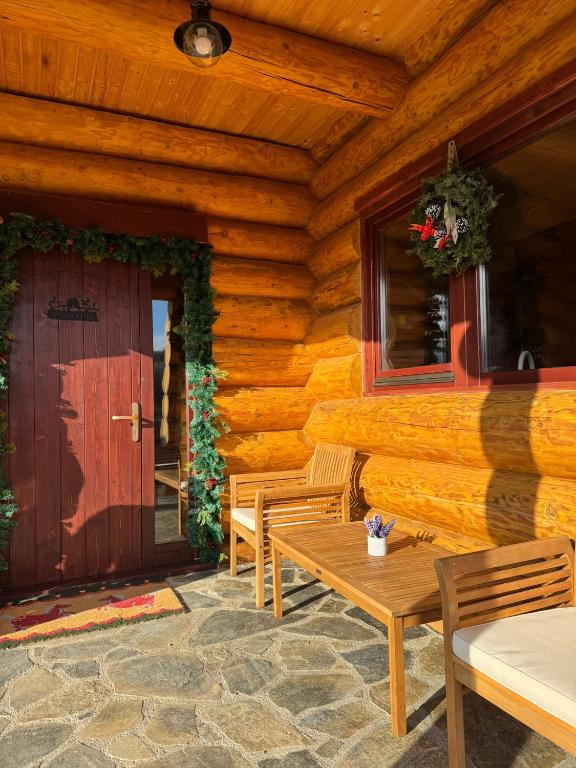 a wooden cabin with a wooden door and chairs and a table at Cabana Om Bun in Piatra