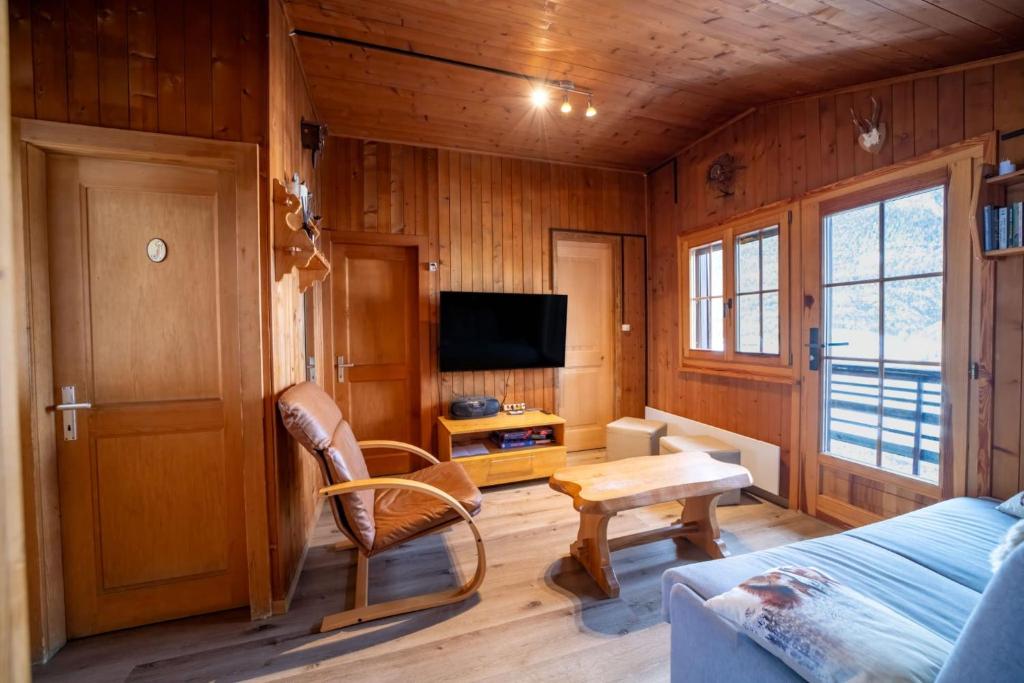 a room with a bed and a table and a tv at Charmant Chalet dans la montagne proche de Verbier in Sembrancher
