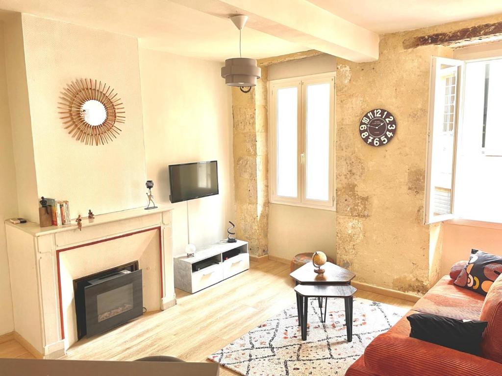a living room with a fireplace and a tv at Alembert - En plein centre ville - 1er étage in Auch