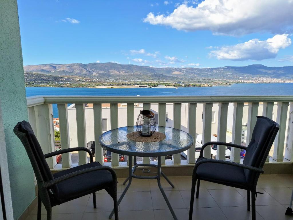a table and chairs on a balcony with a view of the water at Apartman Fishers View in Trogir