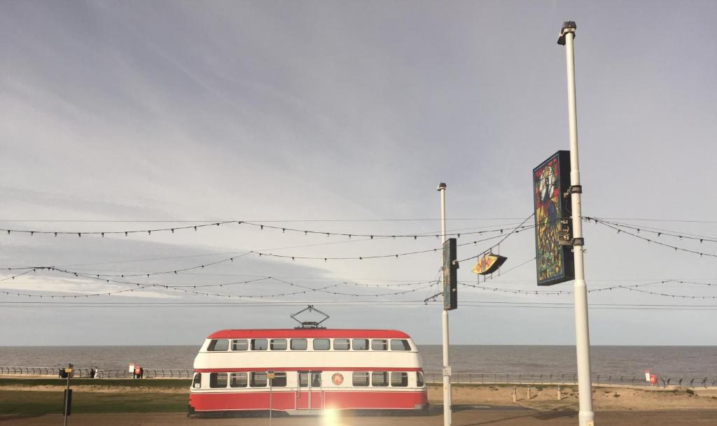 a red and white bus parked next to the beach at Seafront419 By Seafront Collection in Blackpool
