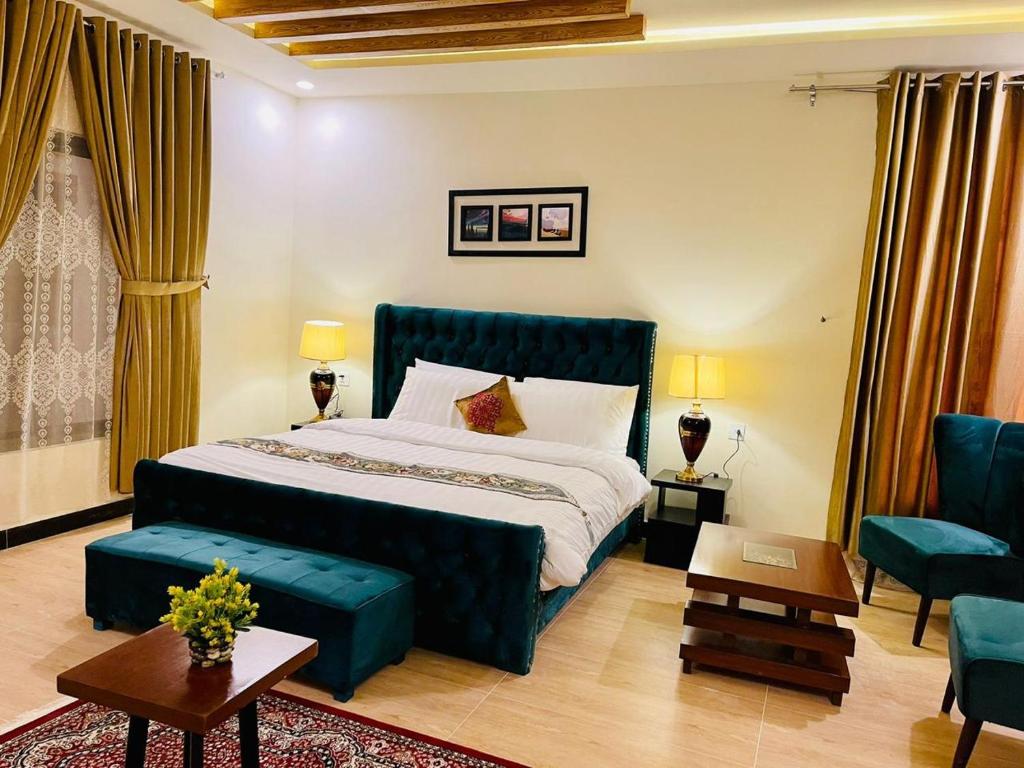 斯瓦特The Corporate Lodges Hotel by Khan Familia Travels的一间卧室，里面有一张大床和一张蓝色沙发。