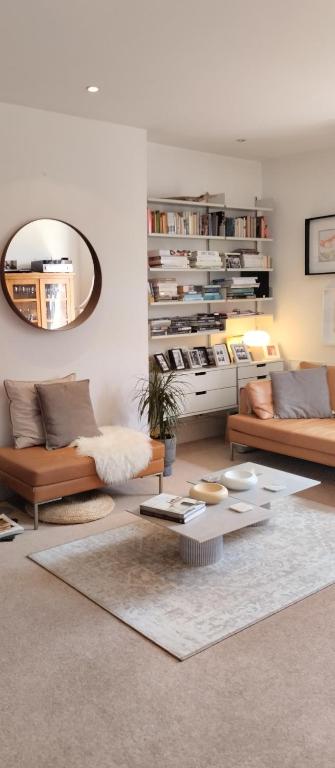 a living room with two couches and a mirror at Cosy oasis with a view in London