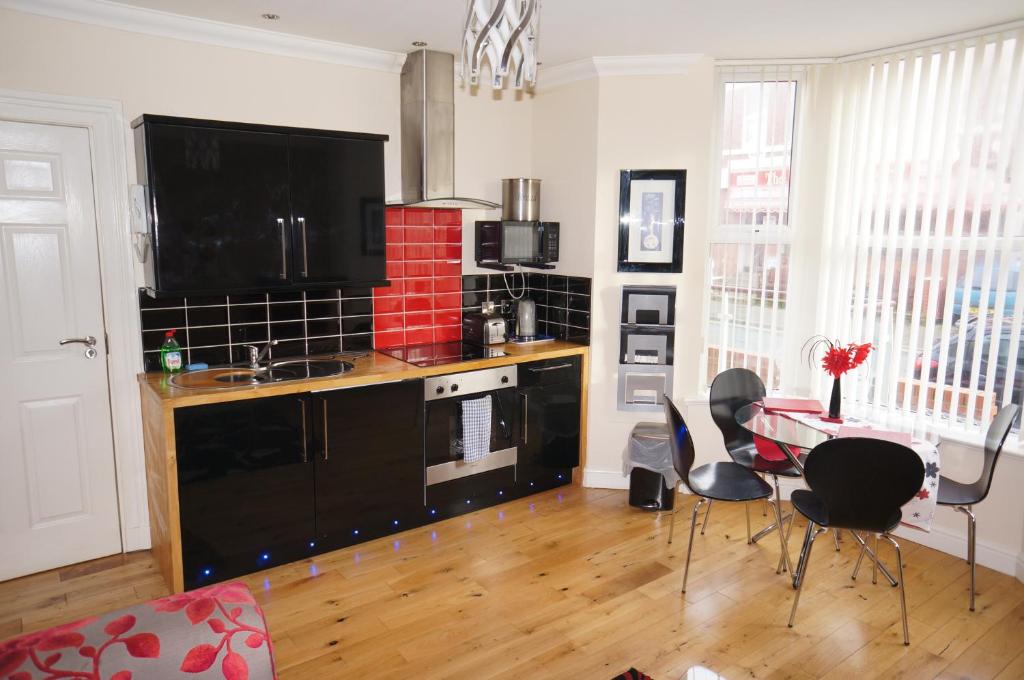 a kitchen with a table and chairs in a room at South Beach Apartments in Blackpool