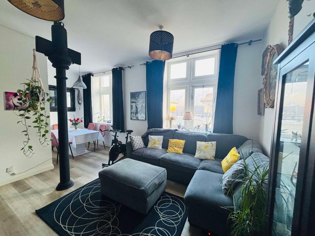 a living room with blue walls and a blue couch at Charming & Modern Flat 2 in Pontypool