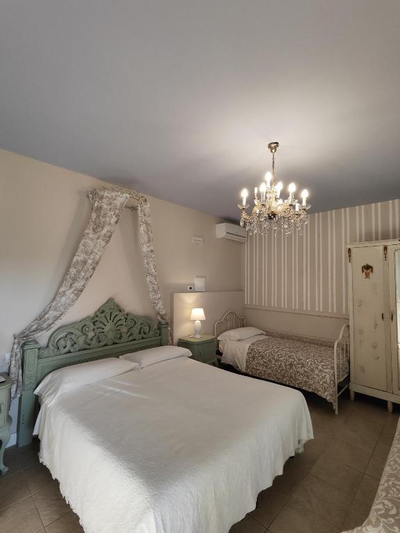 sypialnia z 2 łóżkami i żyrandolem w obiekcie Garda Relais Antica Romelia w mieście Montichiari