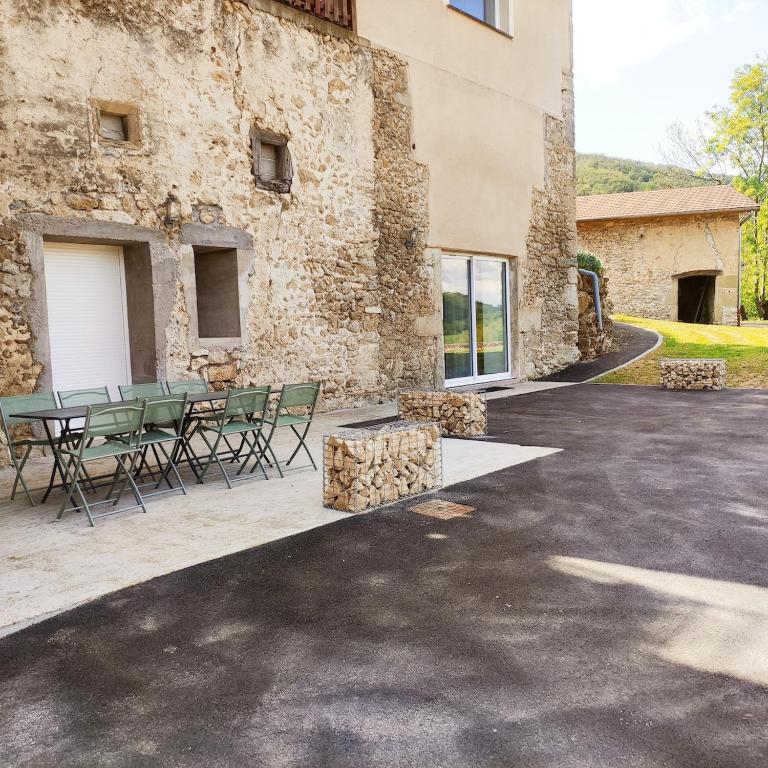 un patio avec une table et des chaises devant un bâtiment dans l'établissement Évasion au cœur du Vercors, à Oriol-en-Royans
