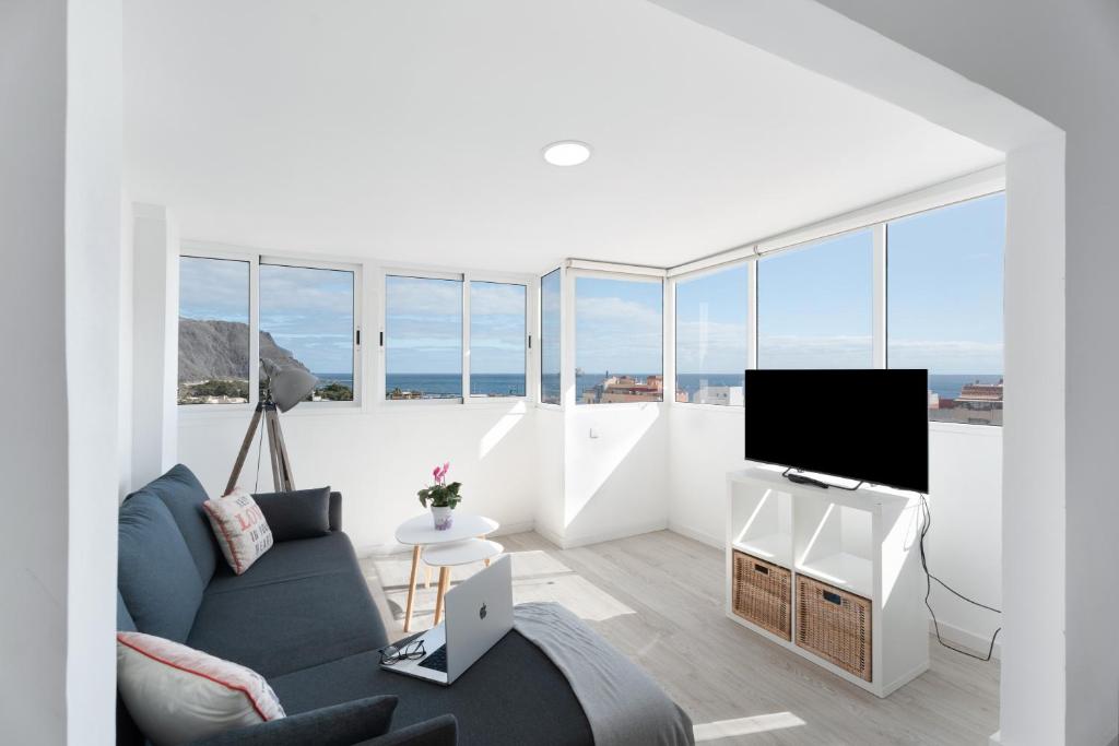 un soggiorno con divano e TV a schermo piatto di Teresitas Beach By Aguita Salada a San Andrés