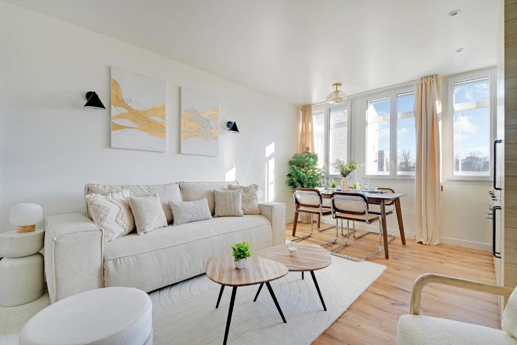 un salon blanc avec un canapé et une table dans l'établissement Pick A Flat's Apartments in Daumesnil - Avenue du General Bizot, à Paris