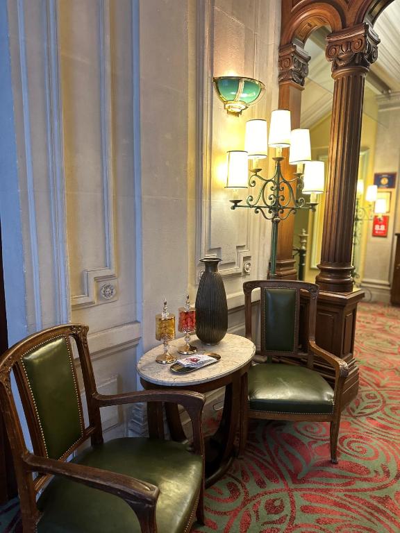 une chambre avec deux chaises et une table avec un vase dans l'établissement Hôtel Langlois, à Paris