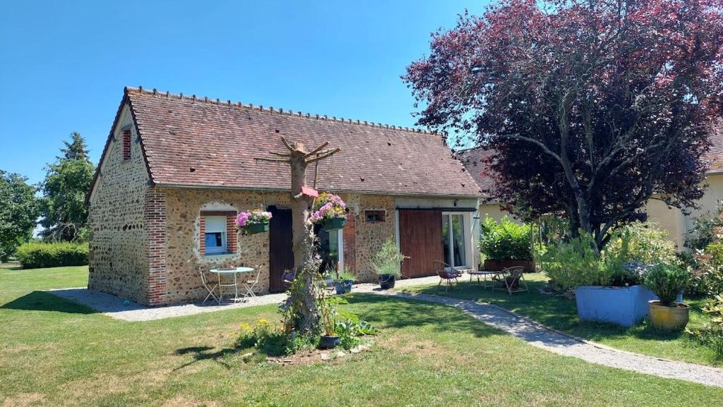 a small brick house in a yard at Chez Mamisa, Calme & Nature in Pullay