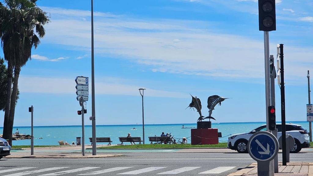 un feu de circulation avec une statue de deux dauphins dans une rue dans l'établissement Charmant studio avec parking, à Cagnes-sur-Mer