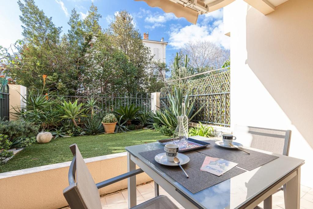 d'une table et de chaises sur un balcon avec un jardin. dans l'établissement Central Terrace Garage & AC, à Cannes