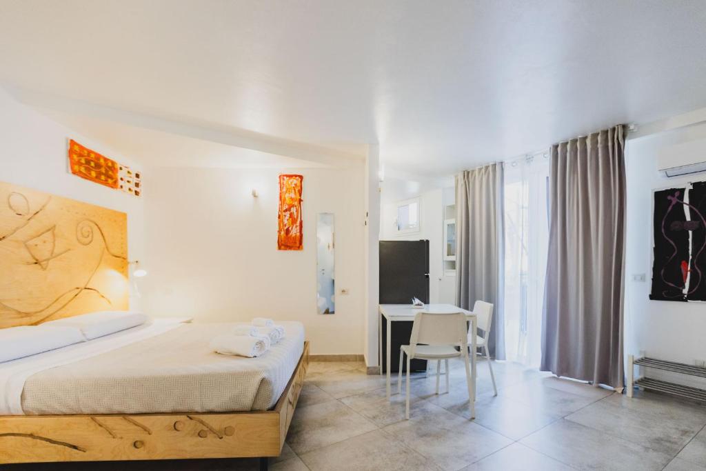 a bedroom with a bed and a table and a desk at Le Cave di Fontane Bianche in Cassibile