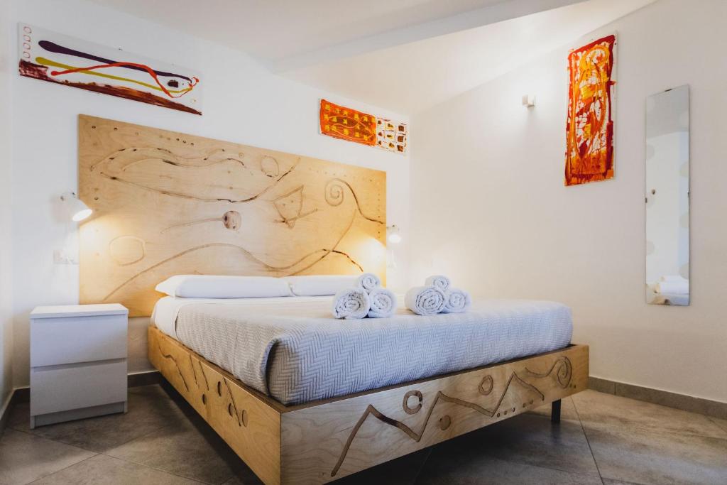 a bedroom with a bed with a wooden headboard at Le Cave di Fontane Bianche in Cassibile