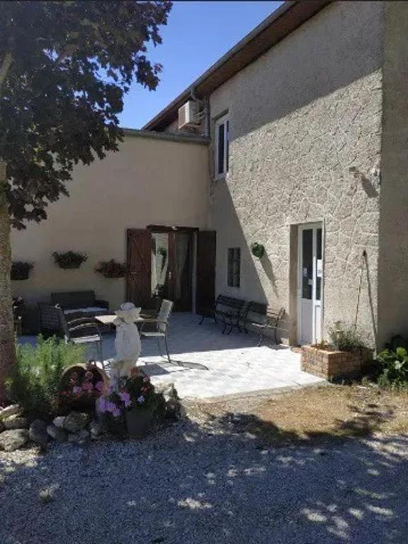 un patio d'une maison avec une table et des chaises dans l'établissement Maison accueillante à Margerie-Hancourt avec jardin 91 m², à Margerie-Hancourt