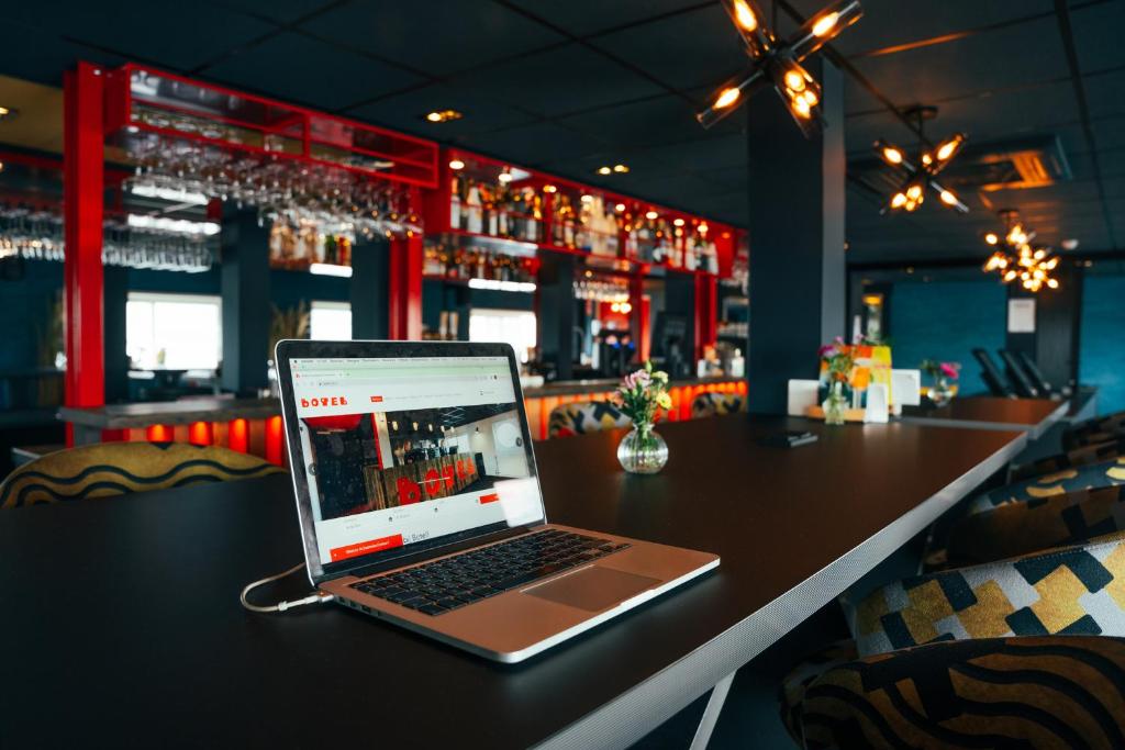 a laptop computer sitting on a table in a bar at Botel in Amsterdam