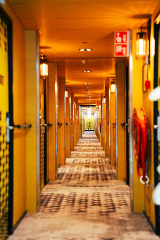 an empty hallway in an office building with yellow walls at Botel in Amsterdam