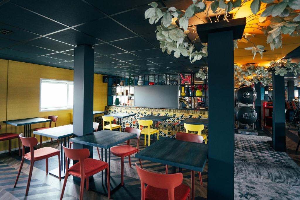 a restaurant with tables and chairs and a screen at Botel in Amsterdam