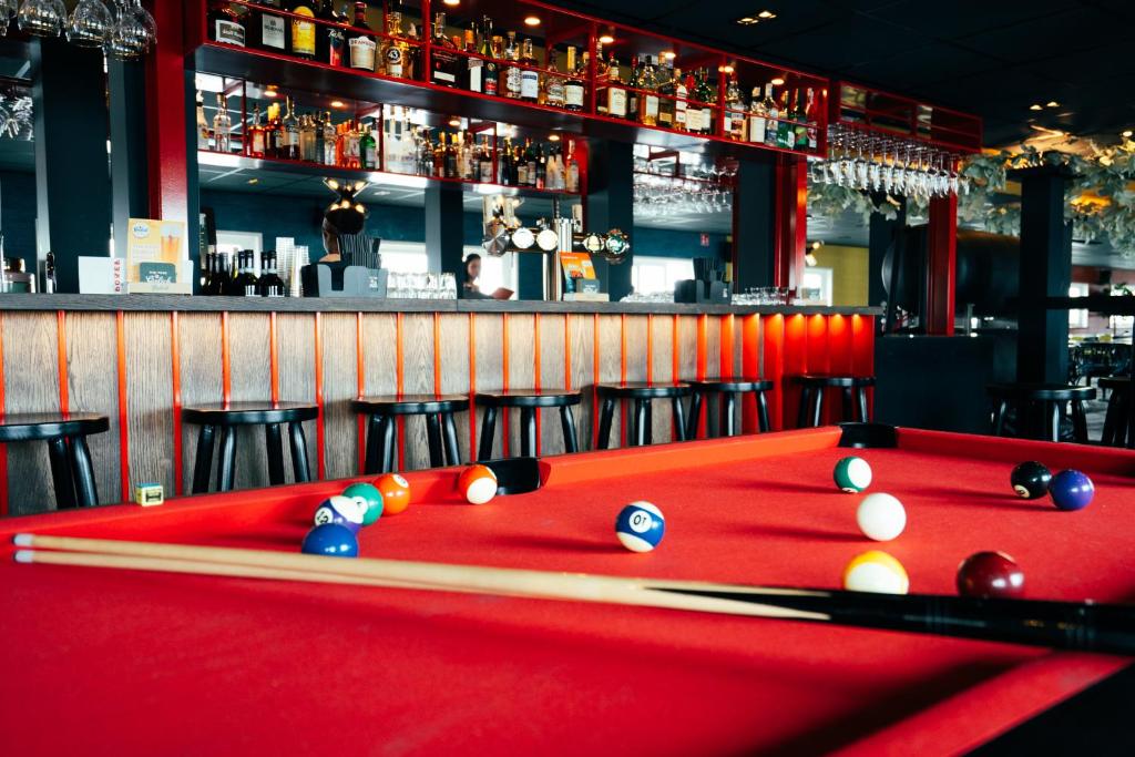 a red pool table with balls on top of it at Botel in Amsterdam