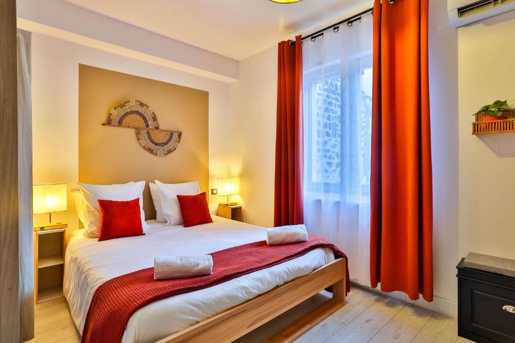 une chambre avec un lit avec des rideaux rouges et une fenêtre dans l'établissement LE LUCIEN Eco-Appart'Hôtel - Angouleme - Centre - Wifi - Parking privé - Classé 4 étoiles, à Angoulême