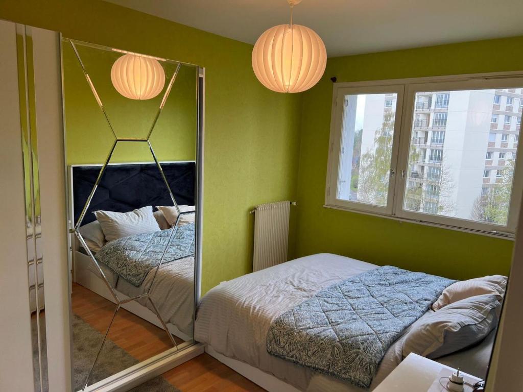 - une chambre avec des murs verts, 2 lits et 2 lampes dans l'établissement Appartement à Caen, à Caen