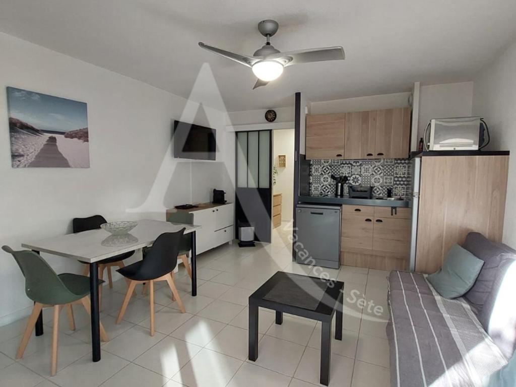une cuisine et un salon avec une table et des chaises dans l'établissement Beau T2 moderne, residence avec piscine - Place de parking, à Sète