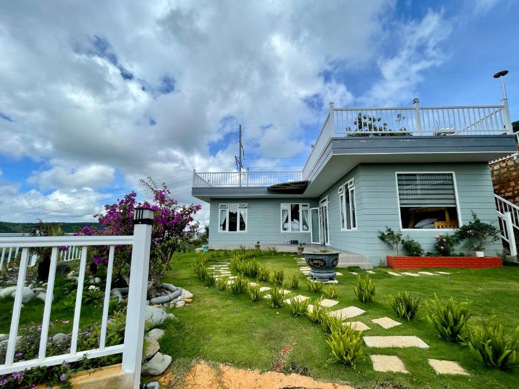 a white fence in front of a house at Green Hill To Feel in Xuân Trường