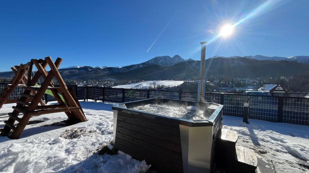 a hot tub on top of a snow covered roof at Korona Giewontu Lux Jaccuzi in Kościelisko