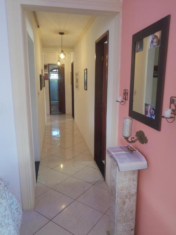 a hallway with pink walls and a tile floor at Sobrado estilo Colonial in Salvador