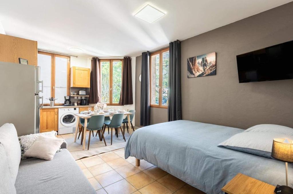 a bedroom with a bed and a kitchen with a table at Laetitsnow Moutiers Ski & Comfort in Moutiers