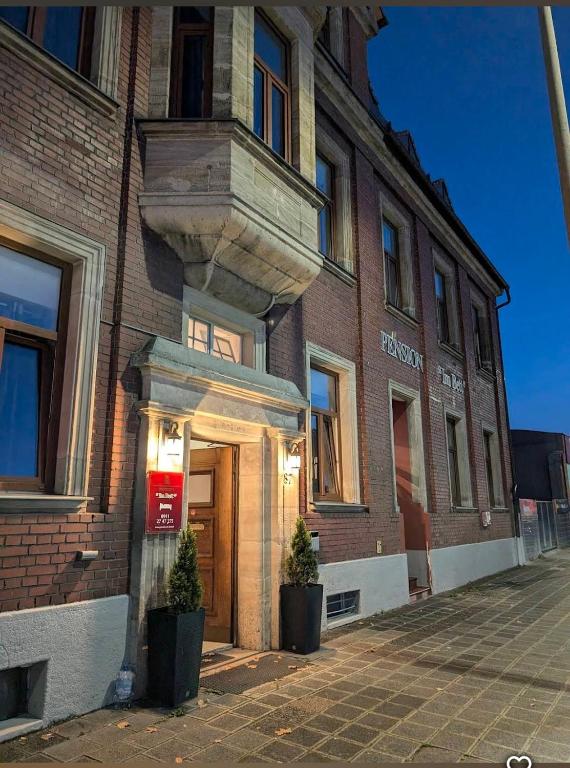 a brick building with a door on a street at Pension Im Bett in Nuremberg