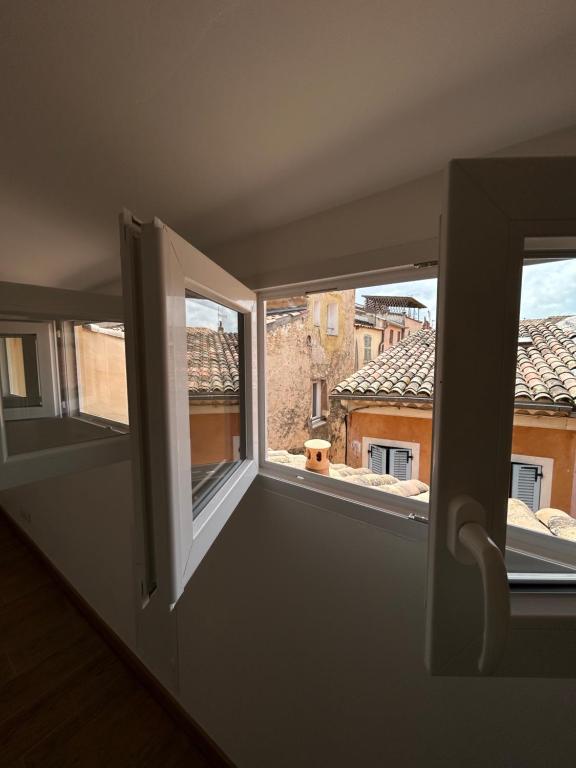 an empty room with two windows and a view at Charmant appart climatisé in Draguignan