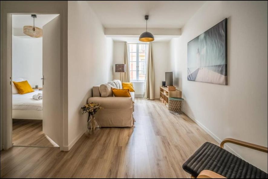 un salon avec un canapé et un lit dans l'établissement Au Pied des Remparts-Cité Médiévale, à Carcassonne