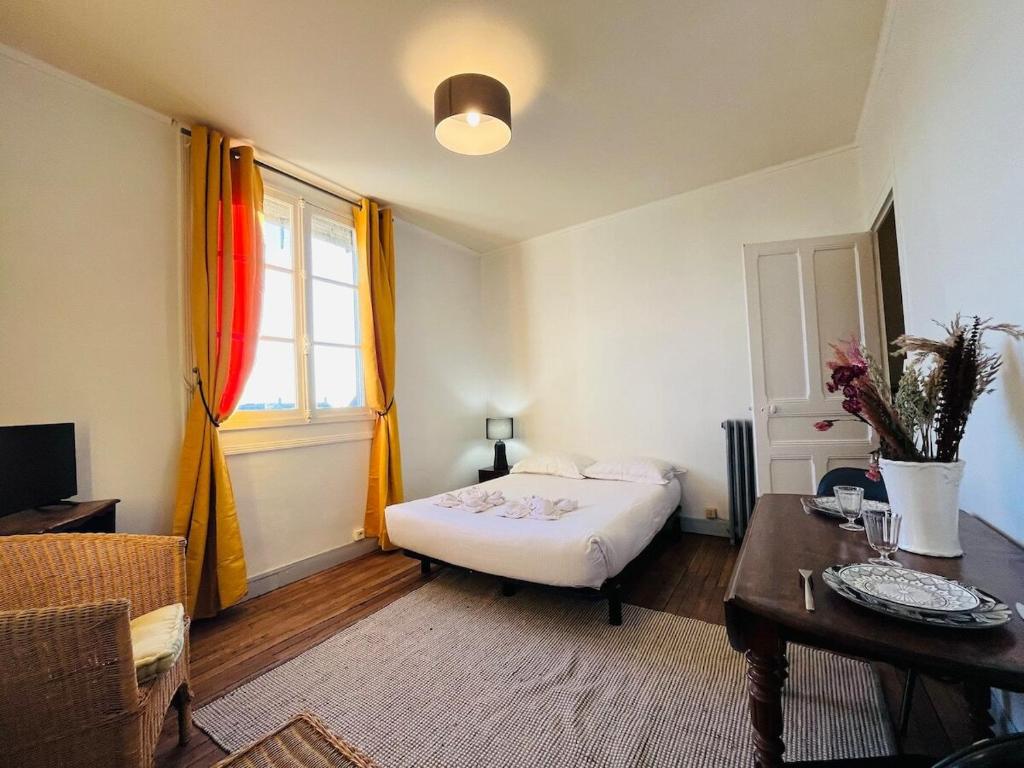 une chambre avec un lit, une table et une fenêtre dans l'établissement Casa Gare, à Angers