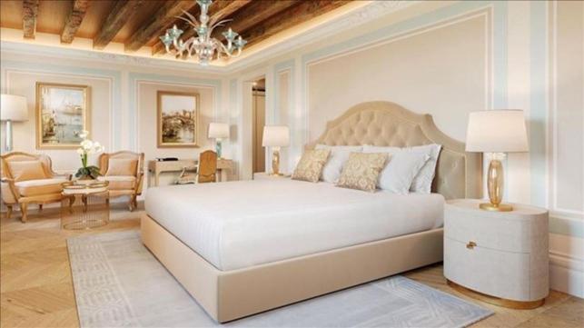 a bedroom with a large white bed and a dining room at Hotel Palazzo Giovanelli e Gran Canal in Venice