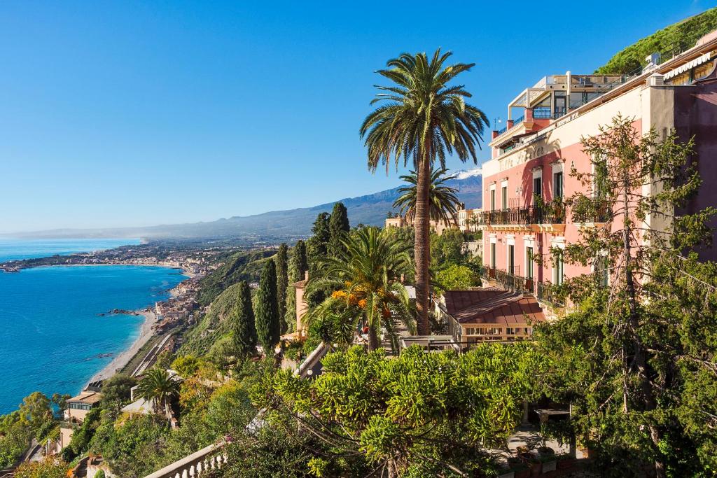 a view of the amalfi coast with palm trees at GARDEN VILLA SUITE - Hotel Villa Schuler in Taormina