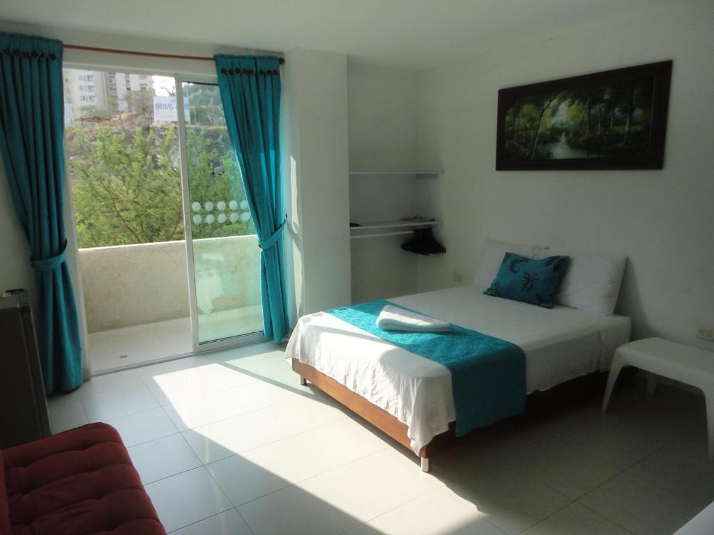 ein Schlafzimmer mit einem Bett und einem großen Fenster in der Unterkunft Brizzamar Hotel in Santa Marta