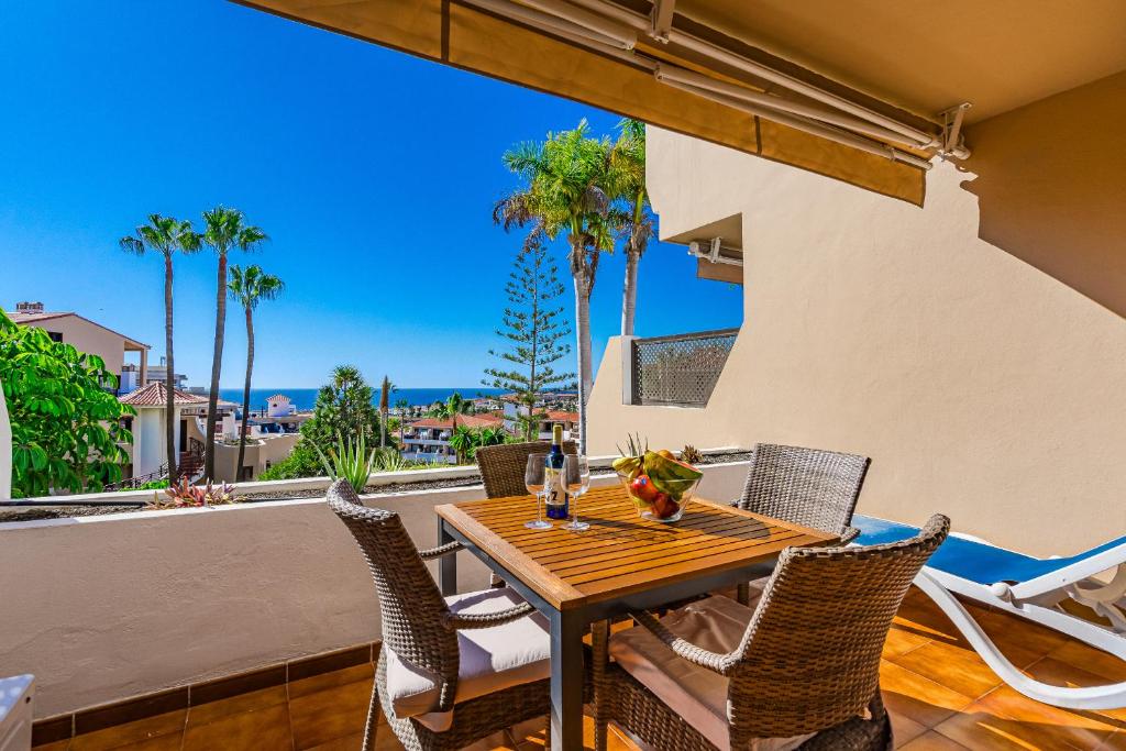 a table and chairs on a balcony with palm trees at Sea View Albatros Golf del Sur in San Miguel de Abona