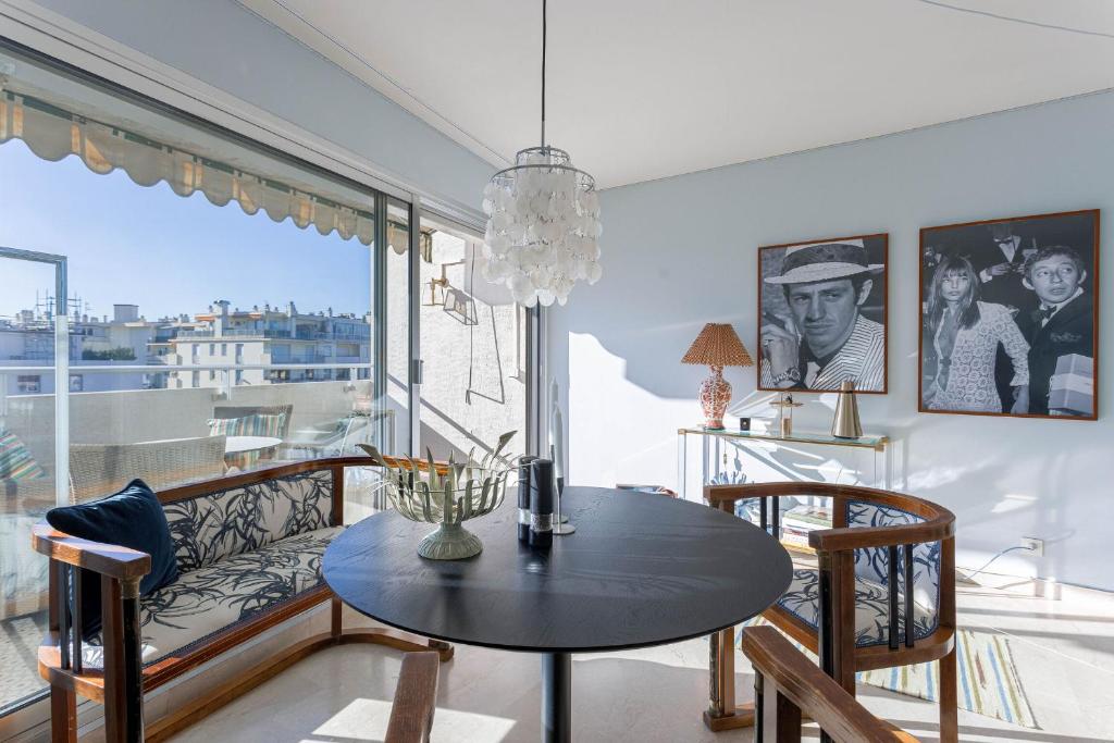 une salle à manger avec une table et une grande fenêtre dans l'établissement Le Goya by Halldis, à Cannes