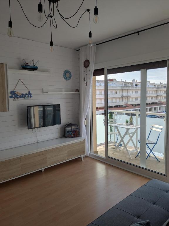 a living room with a flat screen tv and a balcony at La CASA BLAVA in Cubelles