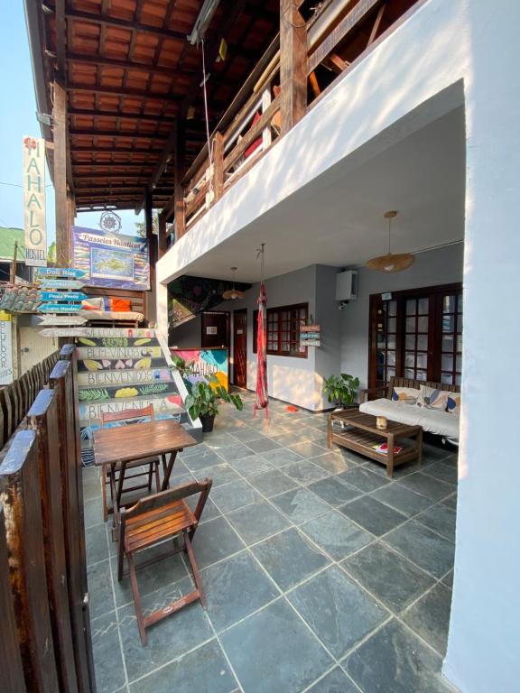 イーリャ・グランデにあるMahalo Hostelのパティオ(テーブル、椅子、ソファ付)